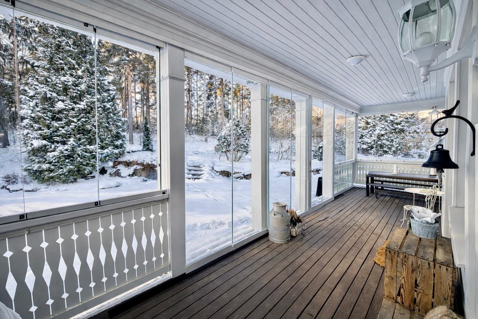 Lasitettu terassi talvella lumisen metsän äärellä