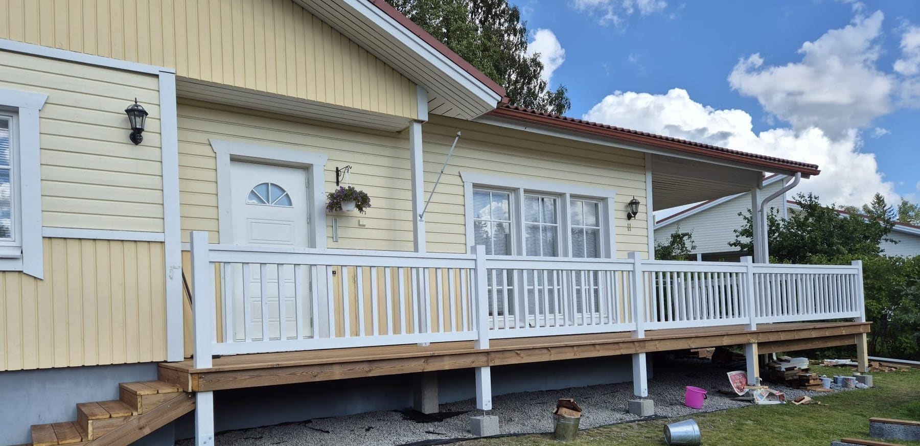 Valmis puurunkoinen patio valkoisella kaiteella